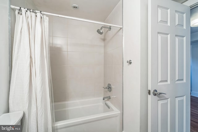 bathroom with shower / tub combo and wood-type flooring