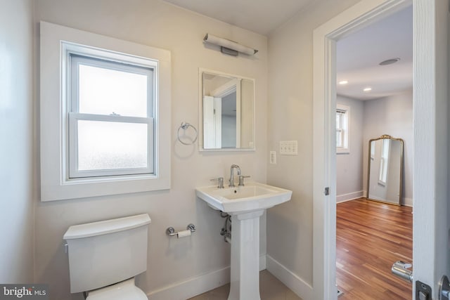 bathroom with toilet, hardwood / wood-style floors, and sink