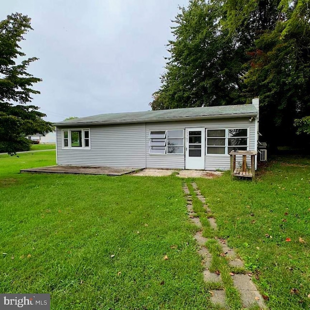 rear view of property featuring a lawn