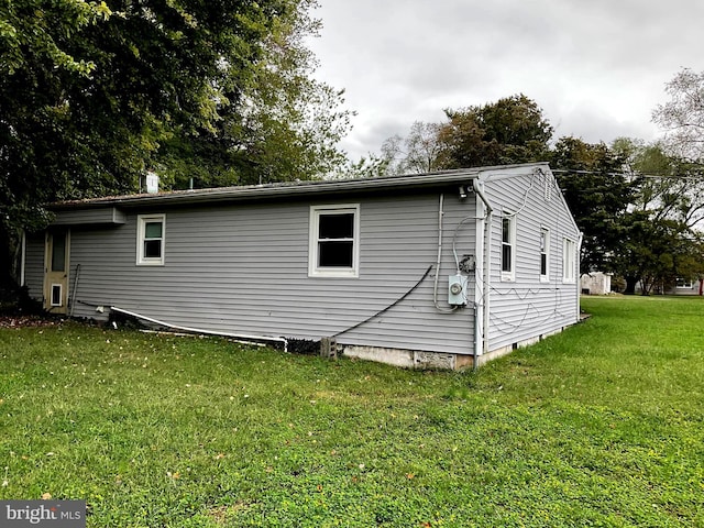 view of side of home with a yard