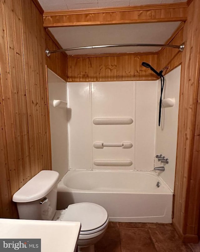 full bathroom featuring wood walls, vanity, tile patterned flooring, shower / tub combination, and toilet