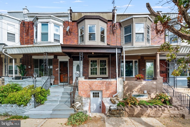 townhome / multi-family property featuring covered porch