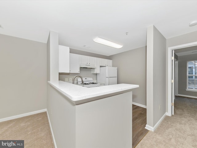 kitchen featuring light carpet, white cabinets, kitchen peninsula, and white appliances