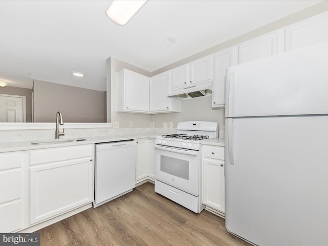 kitchen with light hardwood / wood-style floors, white cabinetry, sink, and white appliances