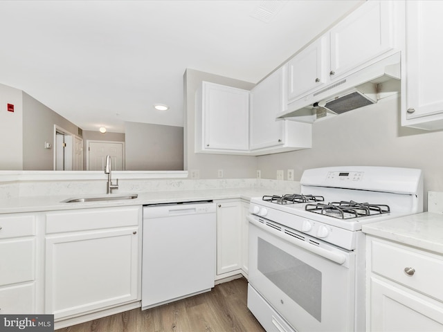 kitchen featuring white cabinets, sink, wood-type flooring, and white appliances