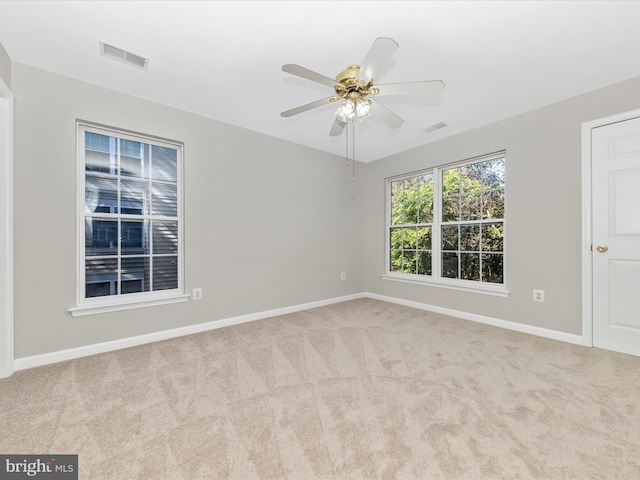 spare room featuring light carpet and ceiling fan