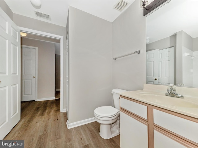 bathroom with toilet, hardwood / wood-style floors, and vanity