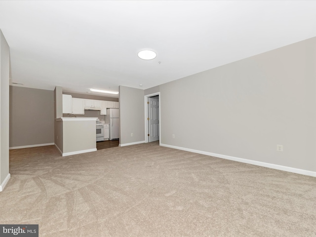 unfurnished living room with light carpet and sink