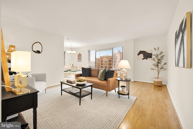 living room with light wood-type flooring and a notable chandelier