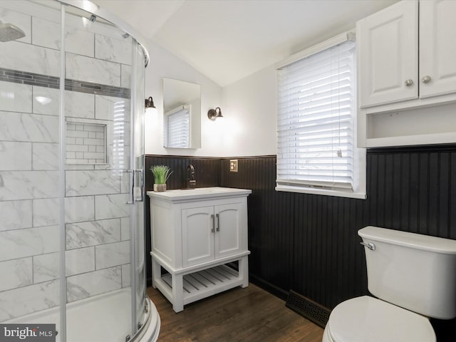 bathroom with vanity, hardwood / wood-style flooring, toilet, and lofted ceiling