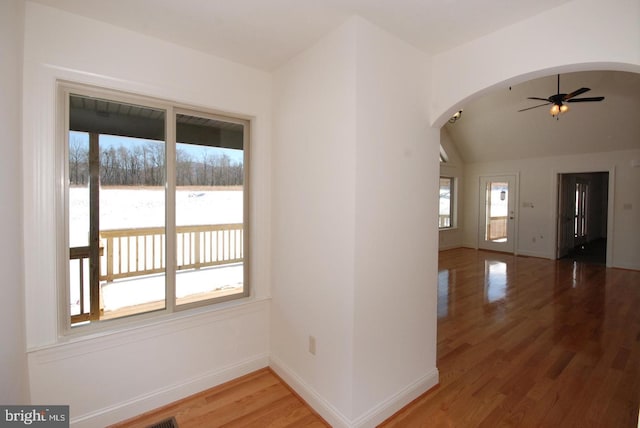 corridor featuring lofted ceiling, a water view, and wood-type flooring