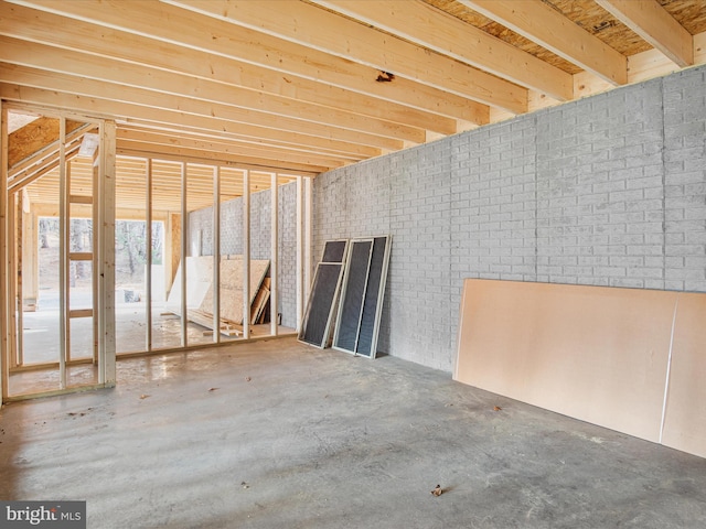 misc room with concrete floors and brick wall