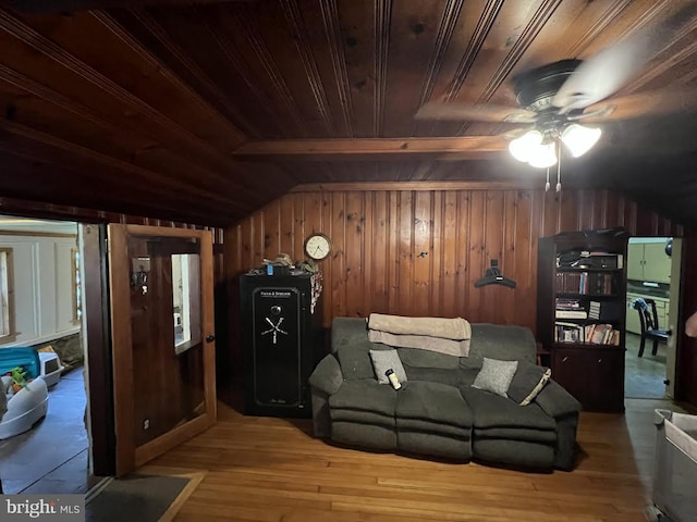 living room featuring lofted ceiling with beams, light hardwood / wood-style flooring, wooden walls, and wood ceiling