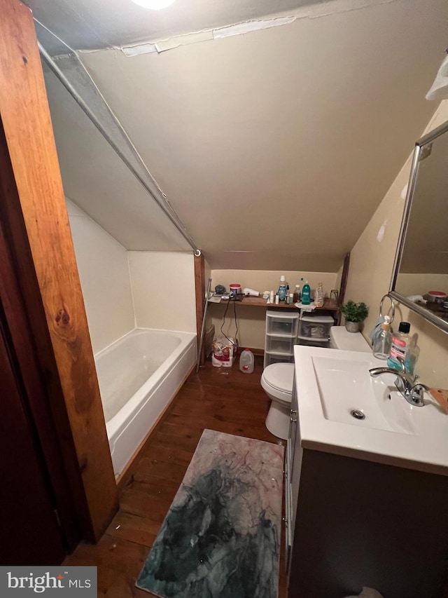 full bathroom with bathtub / shower combination, vanity, hardwood / wood-style floors, toilet, and lofted ceiling