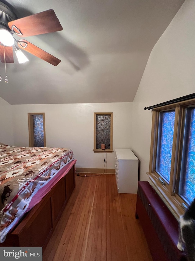 bedroom featuring ceiling fan, light hardwood / wood-style floors, and lofted ceiling