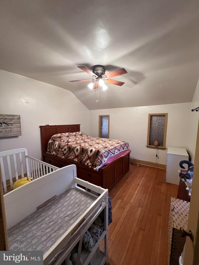 bedroom featuring wood-type flooring, vaulted ceiling, and ceiling fan