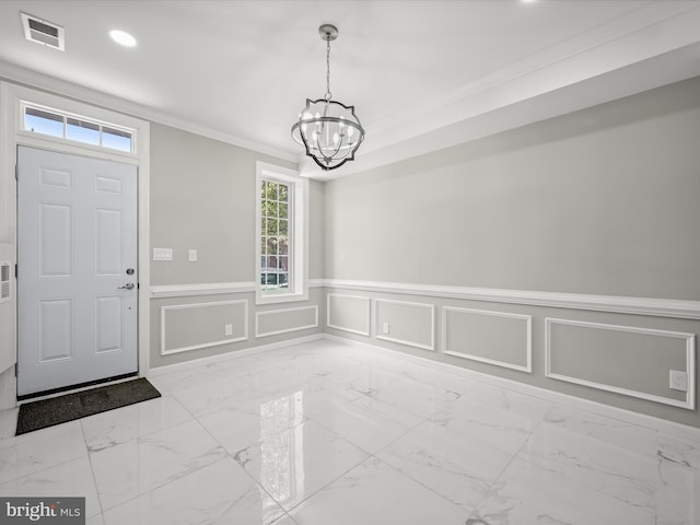 foyer featuring an inviting chandelier, plenty of natural light, and crown molding