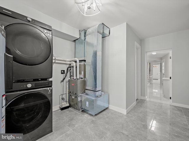 laundry room with stacked washer / dryer and an inviting chandelier