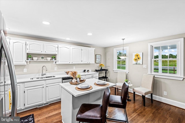 kitchen with pendant lighting, sink, white cabinets, dark hardwood / wood-style flooring, and stainless steel fridge