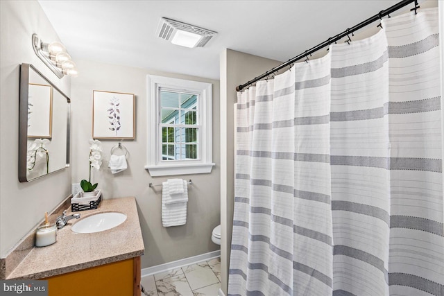 bathroom featuring vanity, toilet, and curtained shower