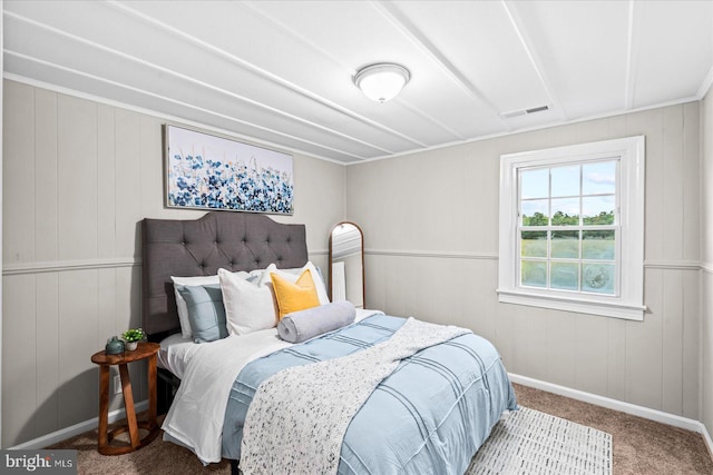 bedroom featuring wood walls and carpet floors