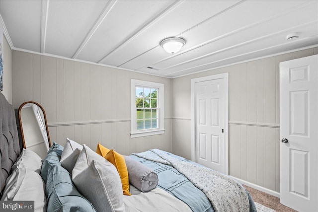 bedroom with wooden walls and carpet