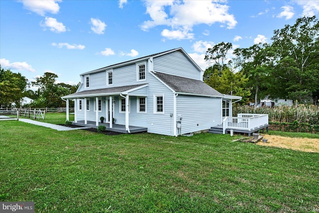 back of house with a lawn and a deck