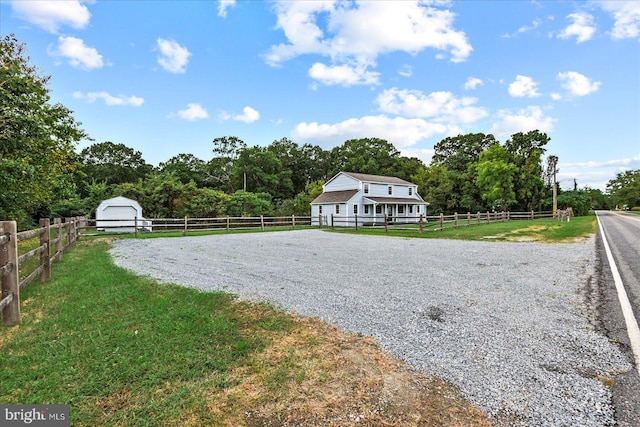 view of yard featuring a rural view and a garage