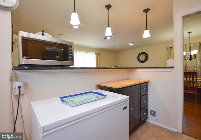 laundry area with a notable chandelier and light wood-type flooring