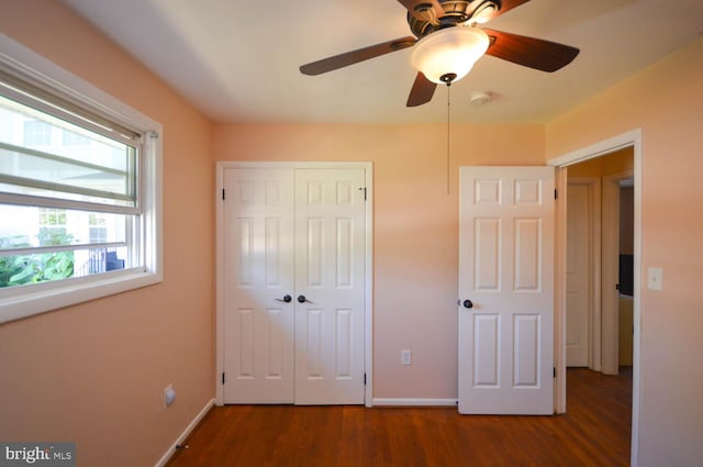 unfurnished bedroom with a closet, ceiling fan, and dark hardwood / wood-style flooring