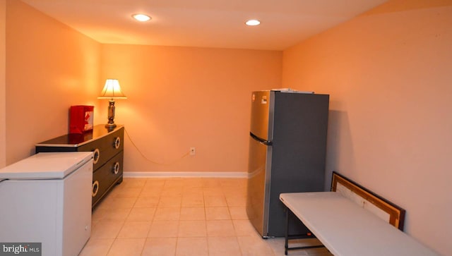 kitchen with light tile patterned flooring and stainless steel refrigerator