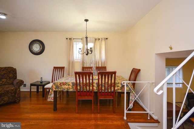 dining space featuring hardwood / wood-style floors and a chandelier