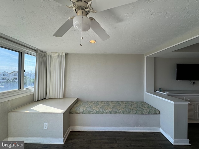 unfurnished bedroom featuring ceiling fan, a textured ceiling, and dark hardwood / wood-style floors