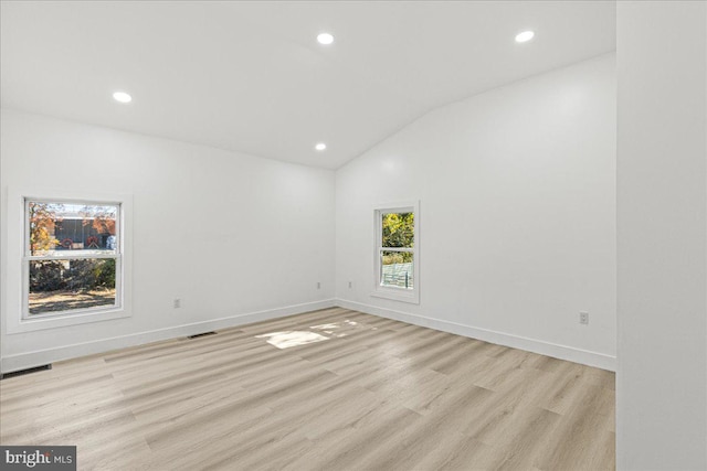 unfurnished room featuring light hardwood / wood-style flooring and vaulted ceiling