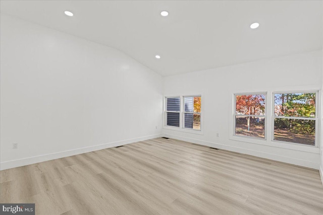 empty room with lofted ceiling and light wood-type flooring