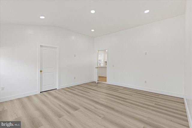 empty room featuring lofted ceiling and light wood-type flooring