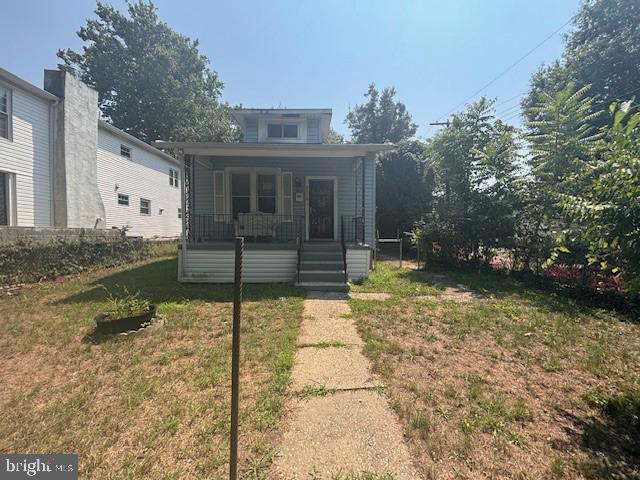 exterior space with covered porch and a front yard