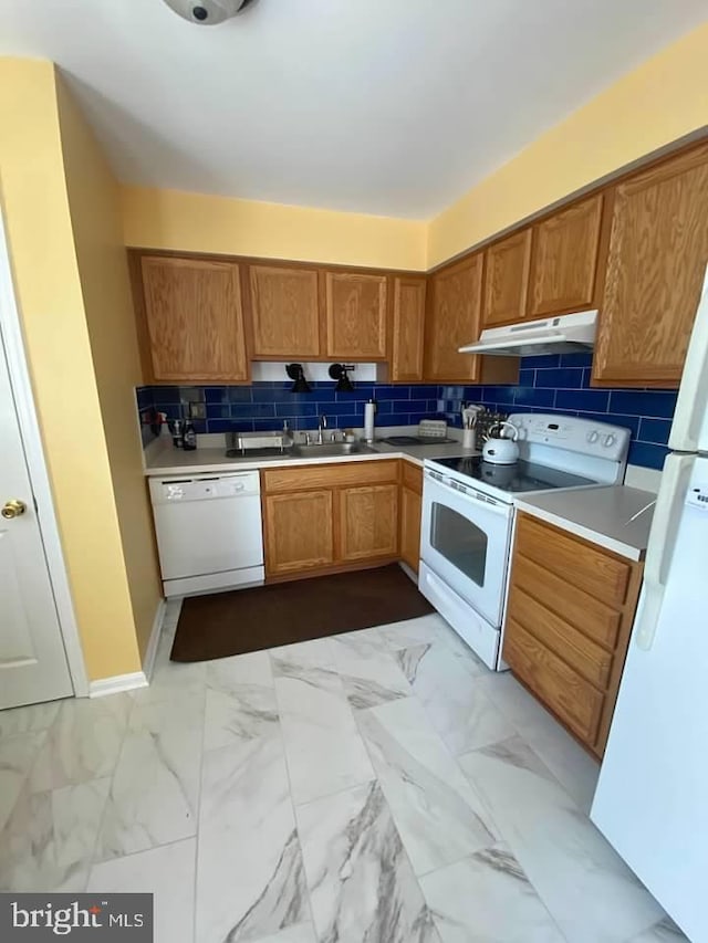 kitchen with decorative backsplash, white appliances, and sink