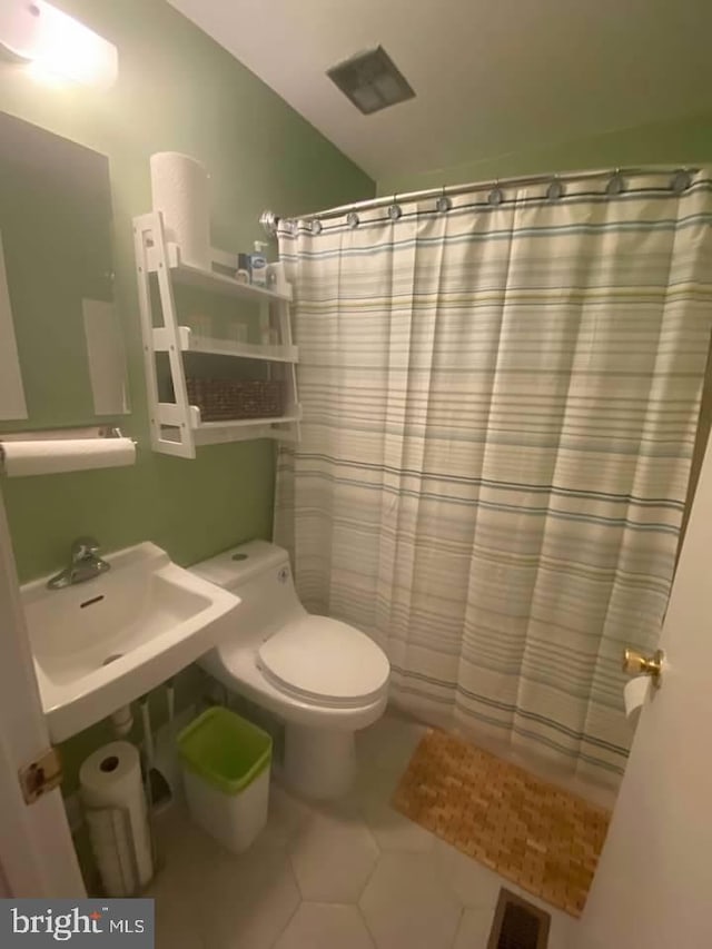 bathroom featuring a shower with shower curtain, sink, tile patterned floors, and toilet