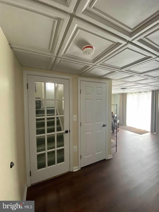 entryway featuring coffered ceiling and dark hardwood / wood-style flooring