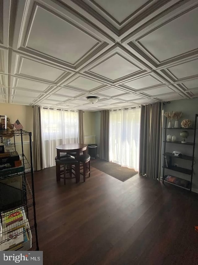 dining space with coffered ceiling and dark wood-type flooring