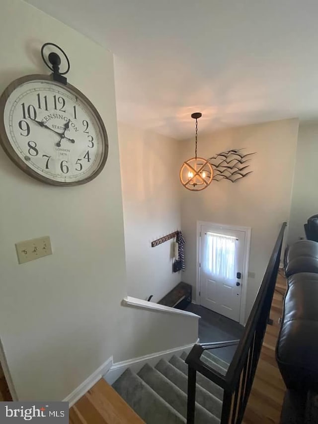 foyer with an inviting chandelier and dark wood-type flooring