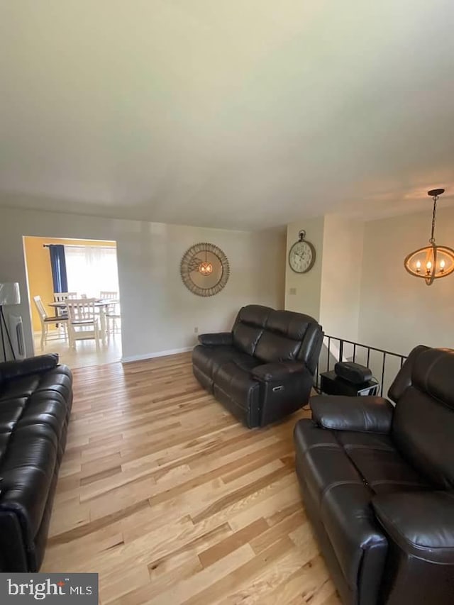 living room featuring light hardwood / wood-style floors and a notable chandelier