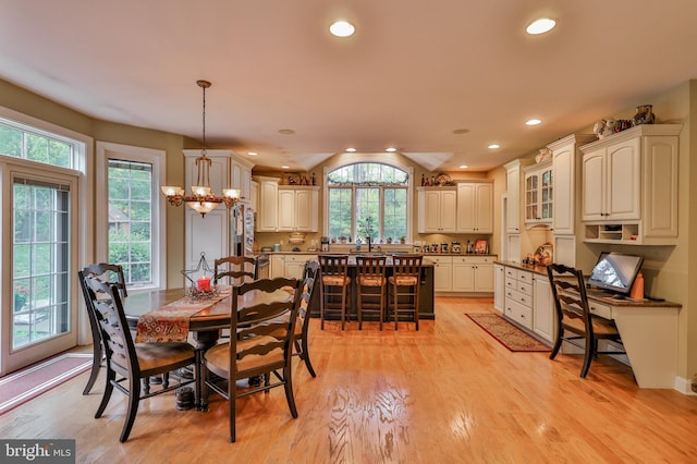 dining room with light hardwood / wood-style flooring and a chandelier