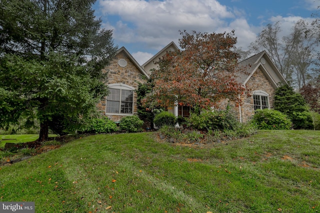 view of property hidden behind natural elements featuring a front lawn