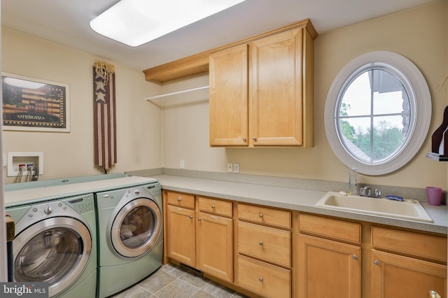 clothes washing area featuring cabinets, washer and dryer, and sink