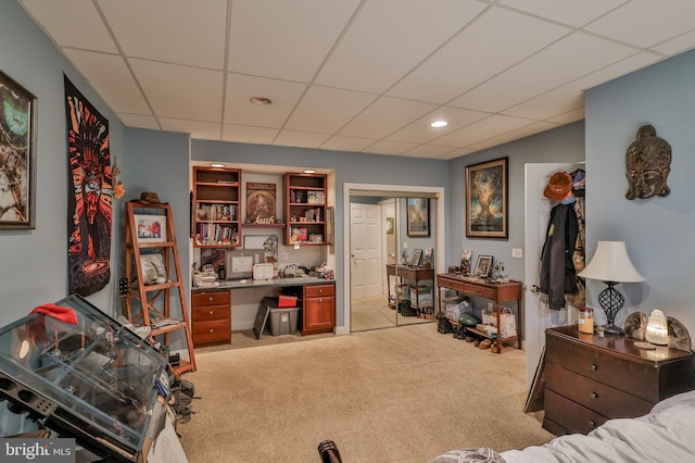 bedroom featuring light carpet and a drop ceiling