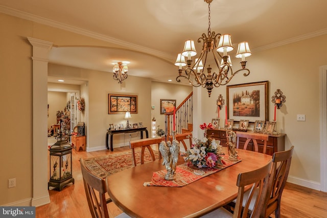 dining area featuring ornamental molding, light wood-type flooring, a chandelier, and ornate columns