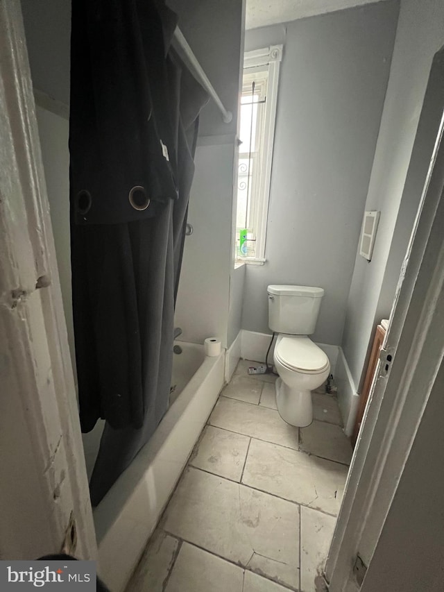 bathroom with shower / tub combo and toilet