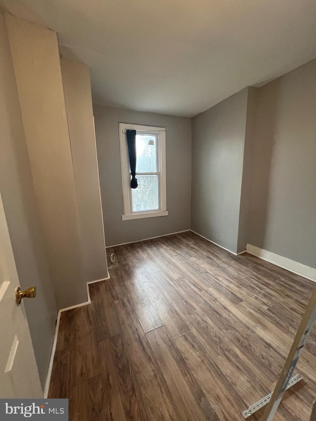 spare room with dark hardwood / wood-style flooring